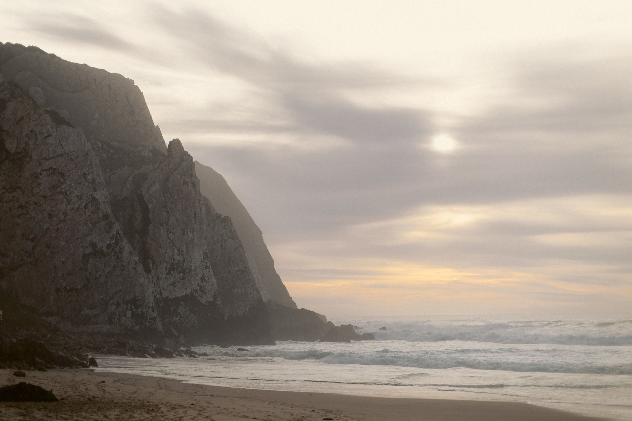 Bethy Lade beach scene with a large rock formation and cloudy sky